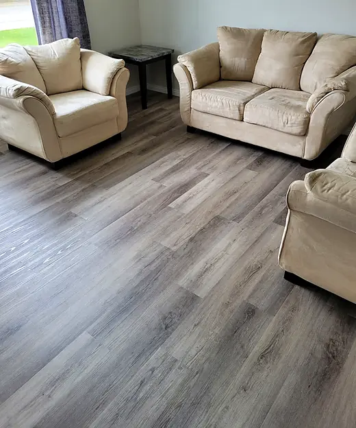 Living room with light gray plank flooring and cream furniture