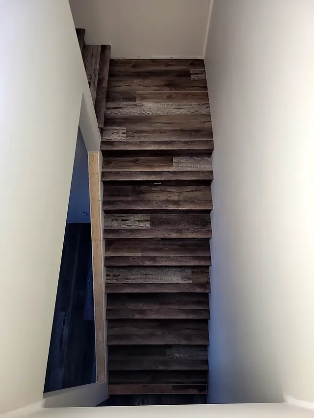 Long staircase with plank flooring on the treads