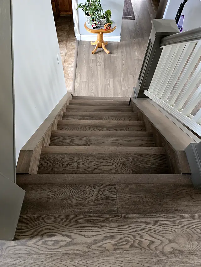 Wood staircase with white balusters, seen from above