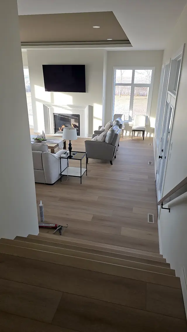 Living room with a fireplace, seen from the top of the stairs